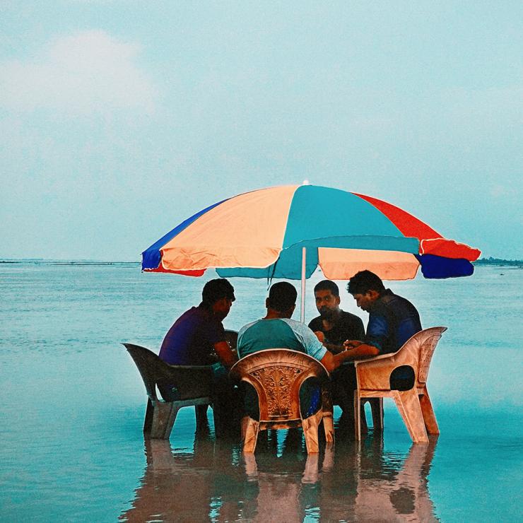 Men sitting in a laguna with table and umbrella